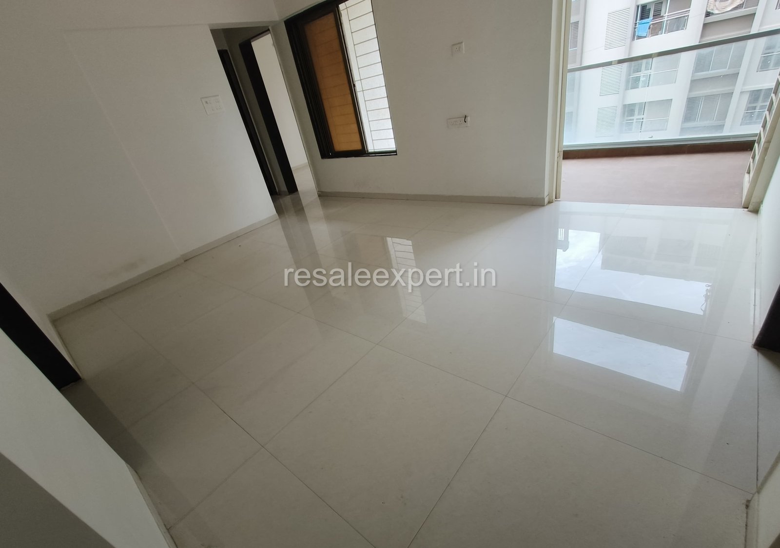 Spacious living room in 3 BHK flat for sale in Pimpri with natural lighting